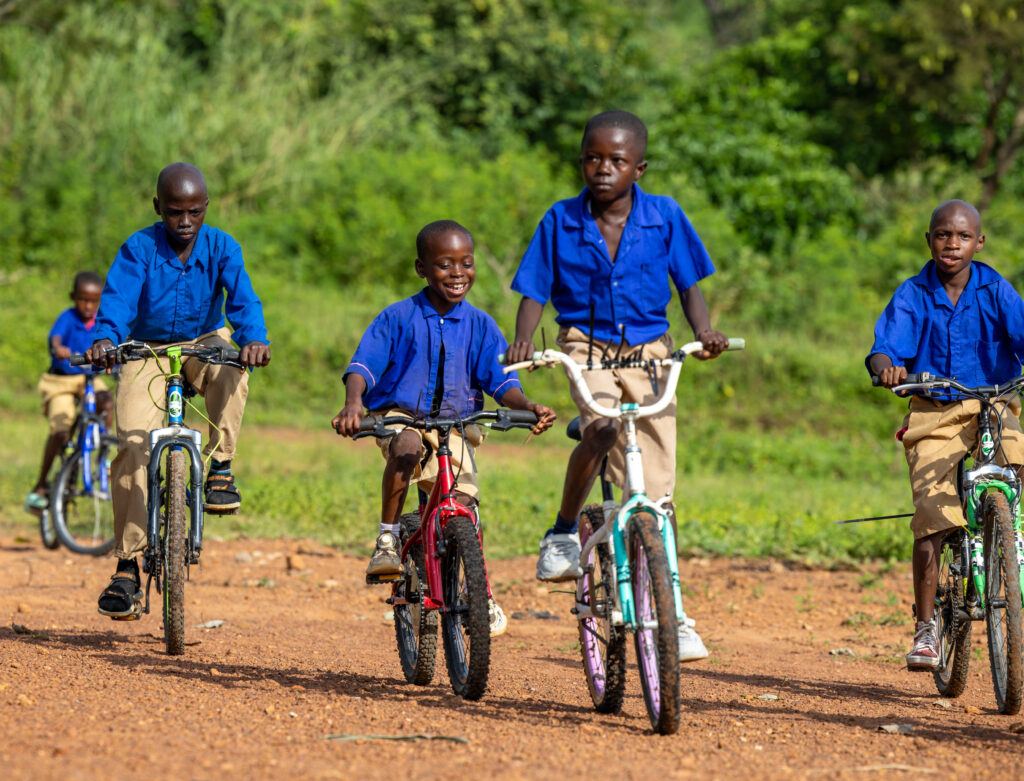 Students riding bicycles to school in a rural Sierra Leone community.